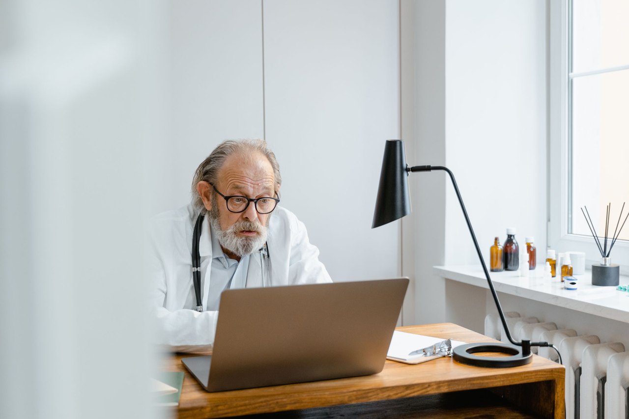 A clinician working at a laptop in a modern care environment