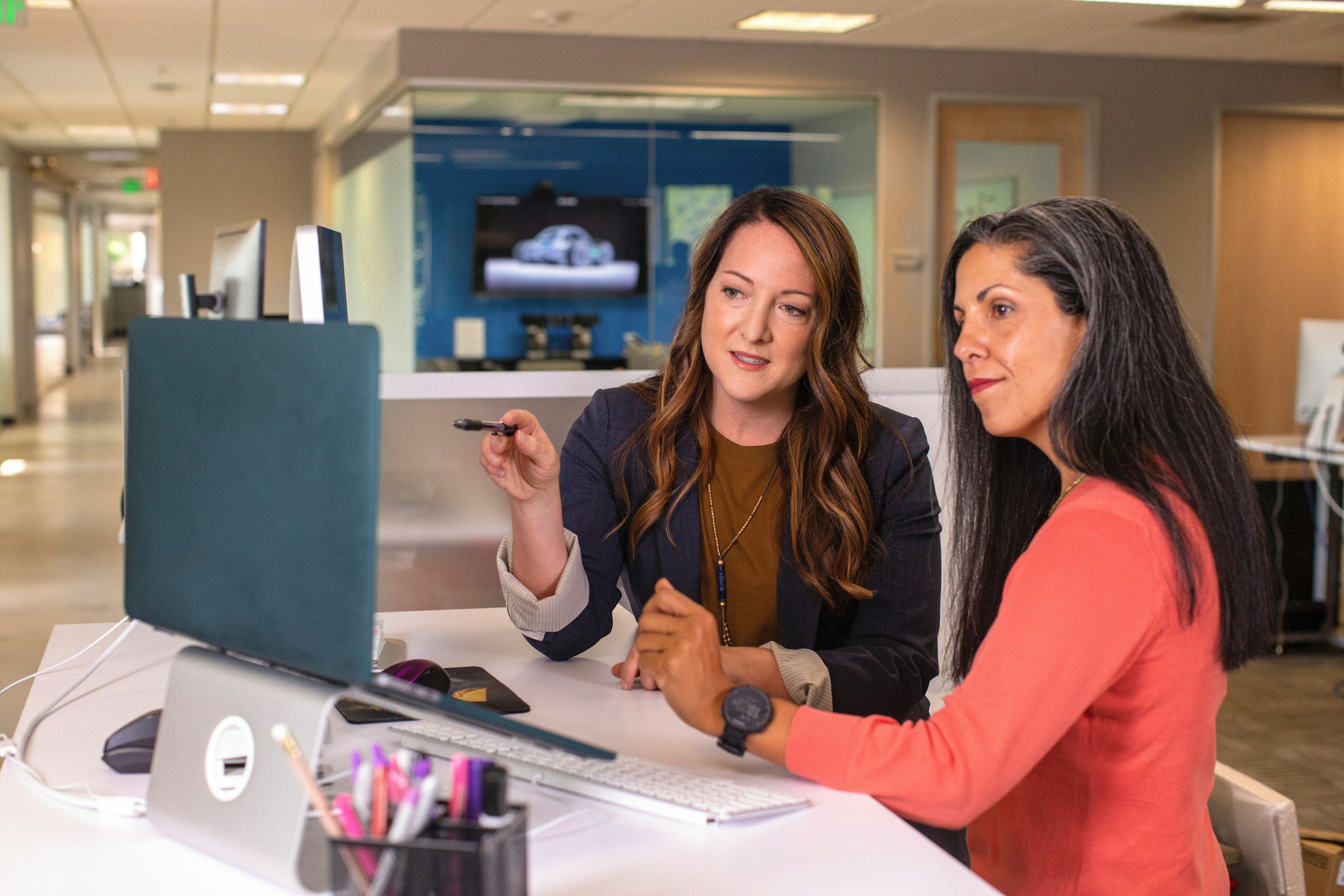 Two professionals reviewing work together at a computer