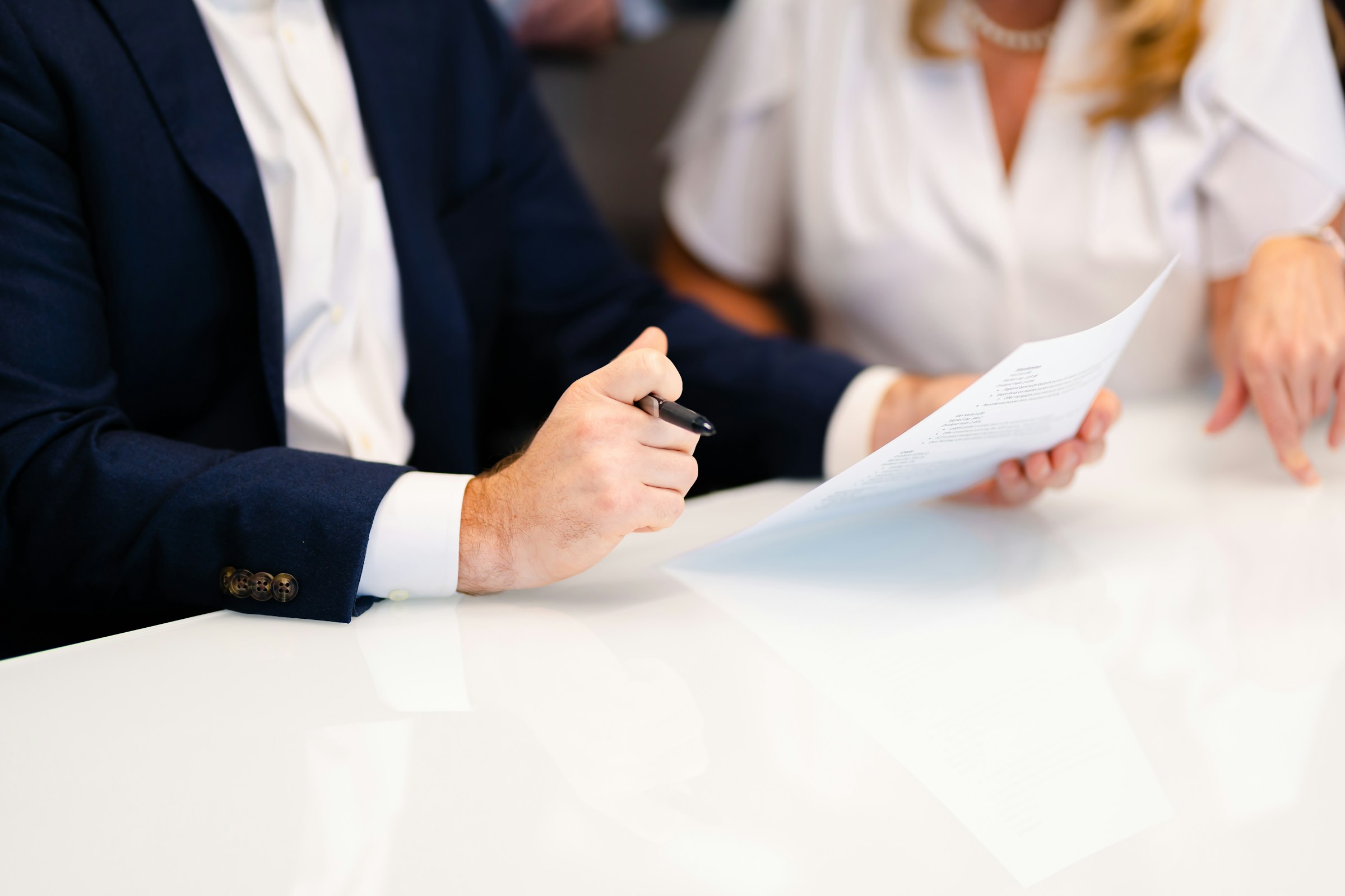 Two colleagues reviewing documents at a meeting table